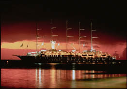 sailing cruise ship in front of a vibrant sunset